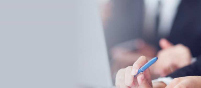 personne devant un ordinateur avec un stylo