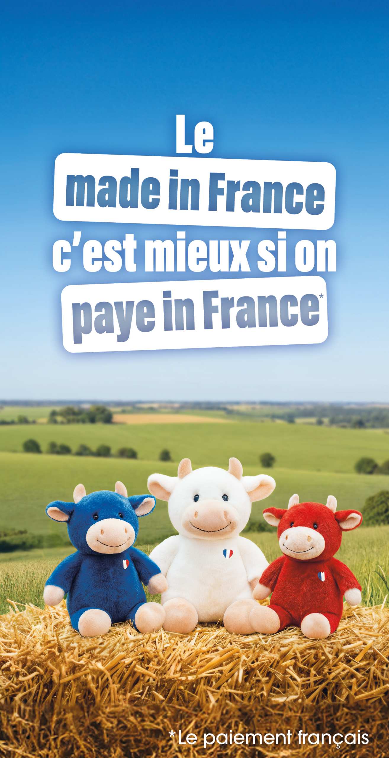 Trois vaches en peluche bleu, blanc et rouge posés sur une botte de foin